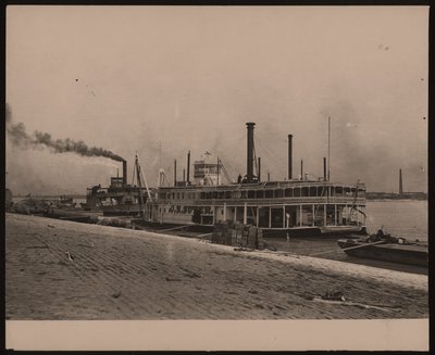 Photographie horizontale en noir et blanc du bateau à vapeur C.R. Suter. Un autre bateau à vapeur est garé derrière et des caisses sont empilées sur le rivage - William G. Swekosky